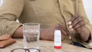 An inhaler and glass of water on a table