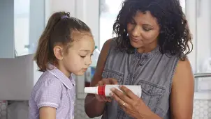 Child and parent looking at a peak flow meter
